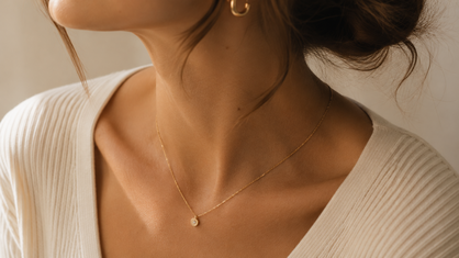 minimalist gold chain necklace and gold hoop earrings on a woman